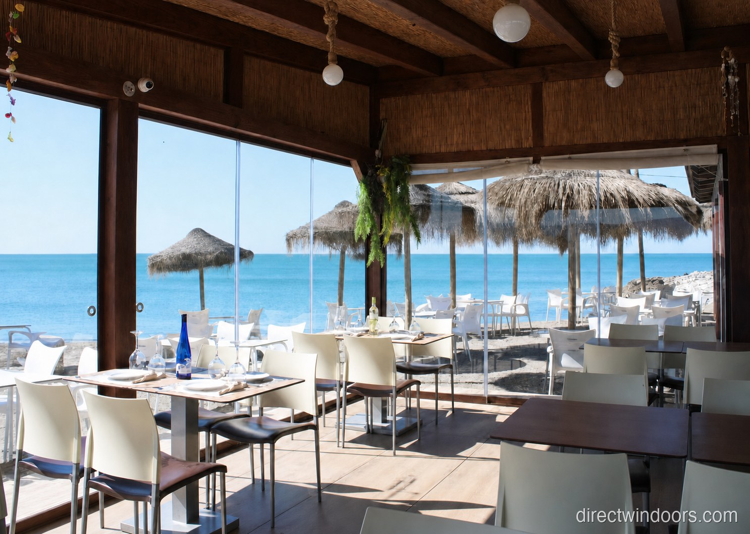 Frameless glass walls on a beachfront restaurant terrace