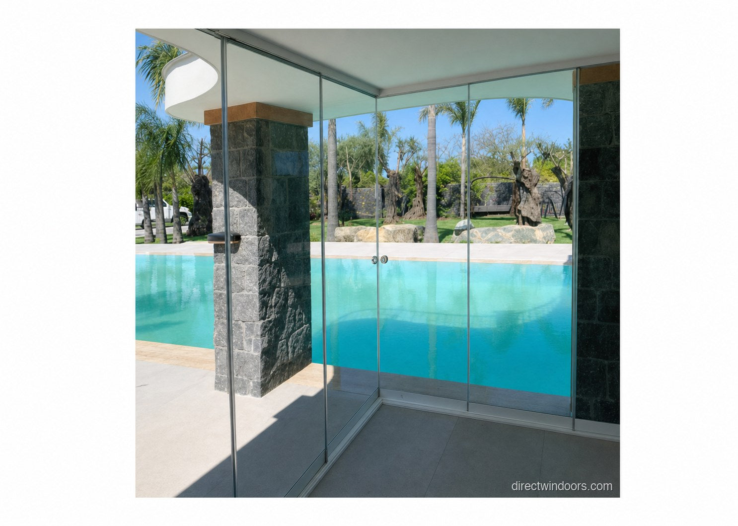 Frameless glass walls corner system overlooking a stone-walled pool