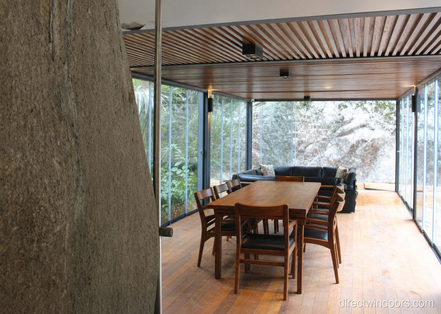 Frameless glass walls between a dining room and outdoor patio