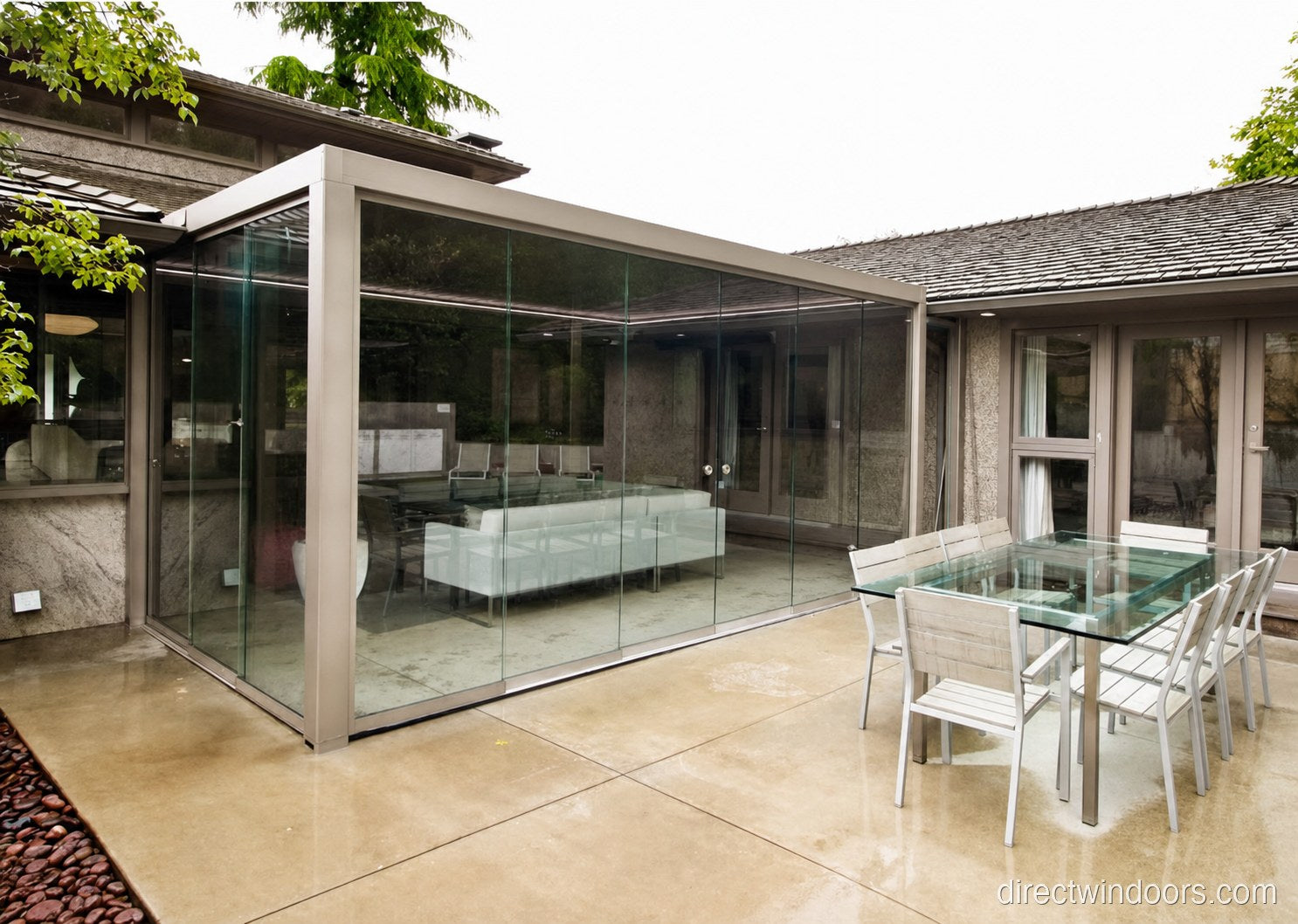 Frameless glass walls on a glazed home extension with garden view